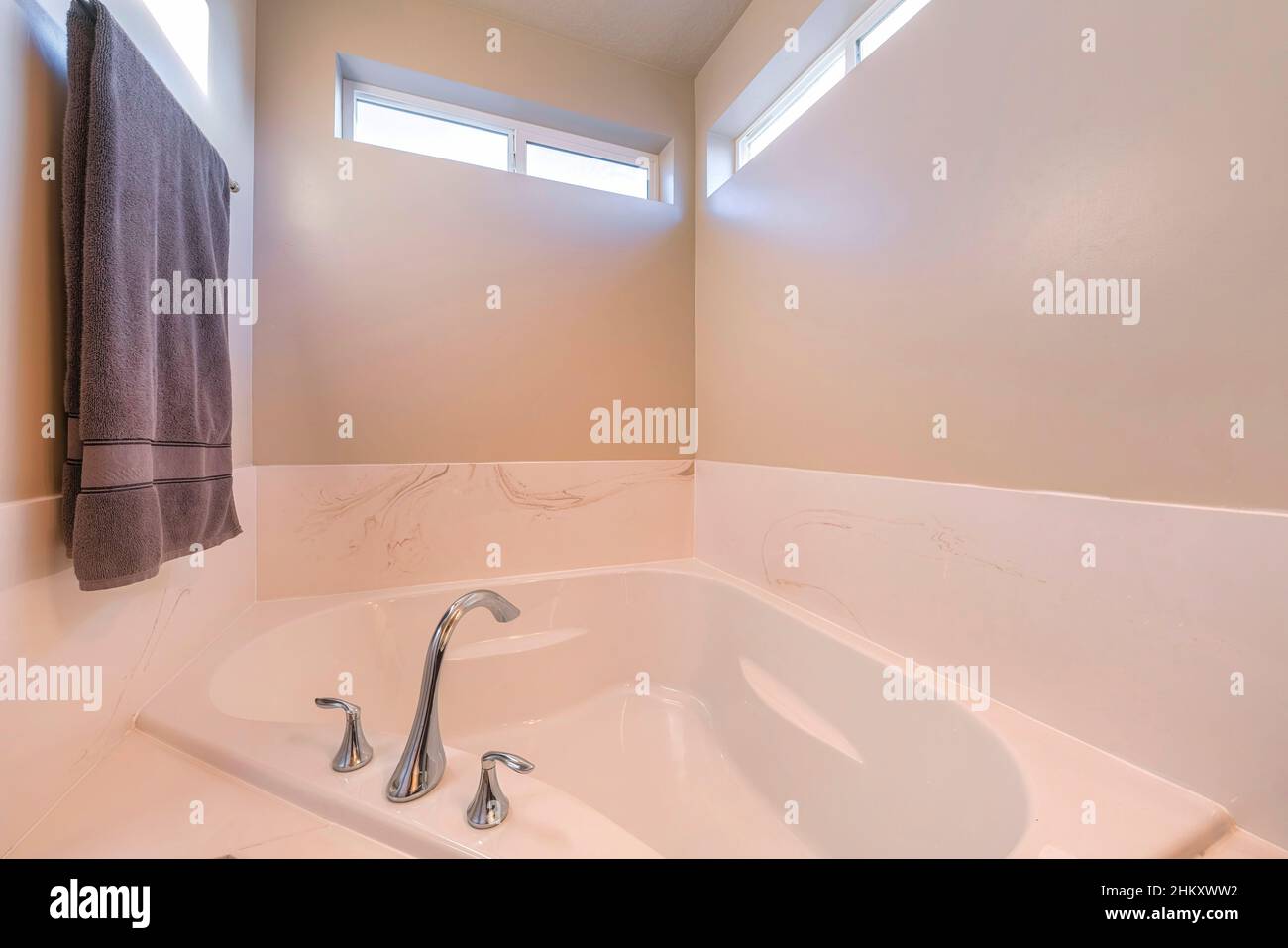 Alcove bathtub with widespread stainless steel faucet Stock Photo - Alamy