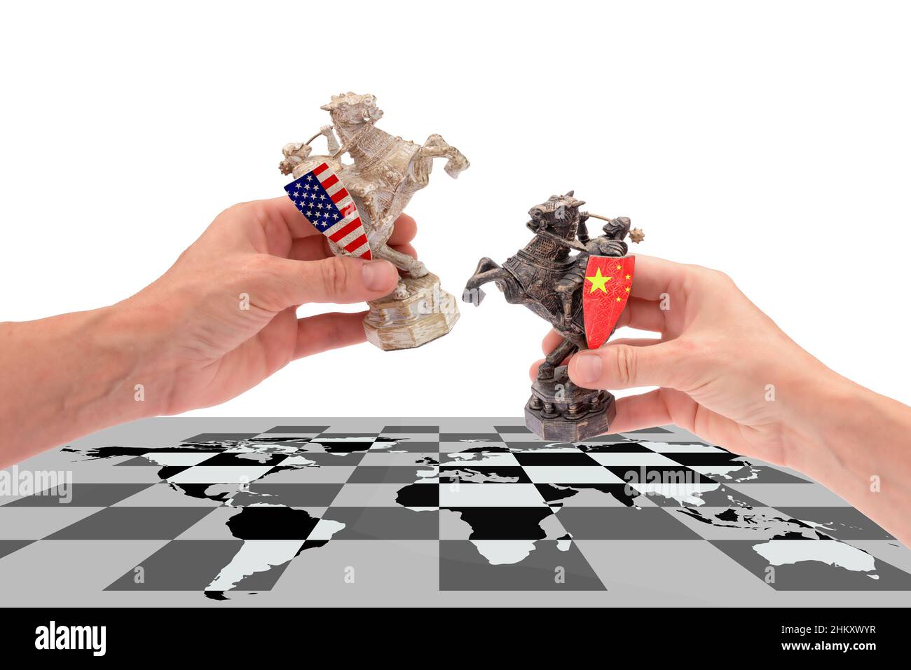Trade war between USA and China. hands hold two chess pieces of a horse, with american and chinese flags placing them on a chessboard with a world map Stock Photo