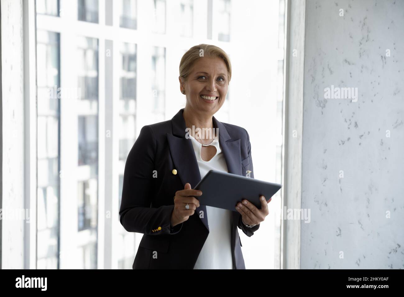Happy successful middle aged businesswoman holding tablet Stock Photo