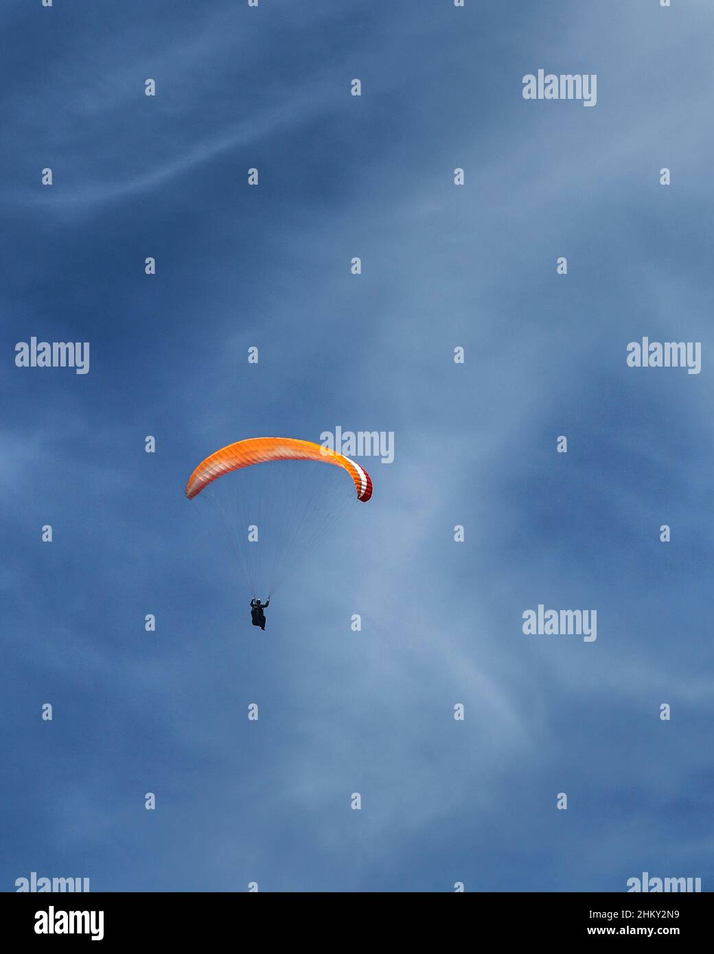Paraglider gliding in the sky, behind clouds, full size, parachute open. Lucern, Switzerland Stock Photo