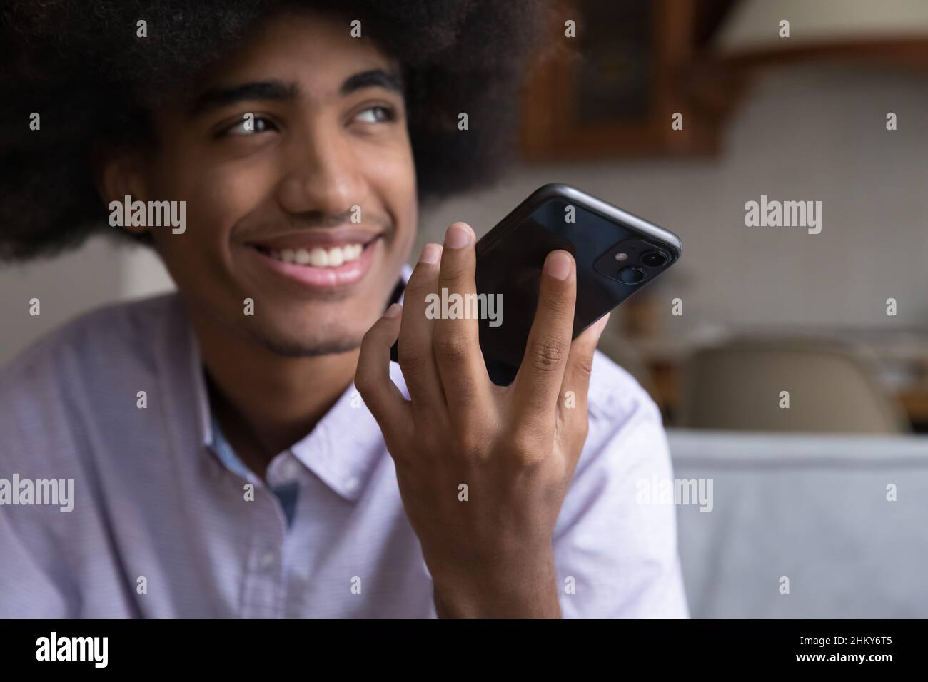 Happy teenage young guy talking on cell on speaker Stock Photo