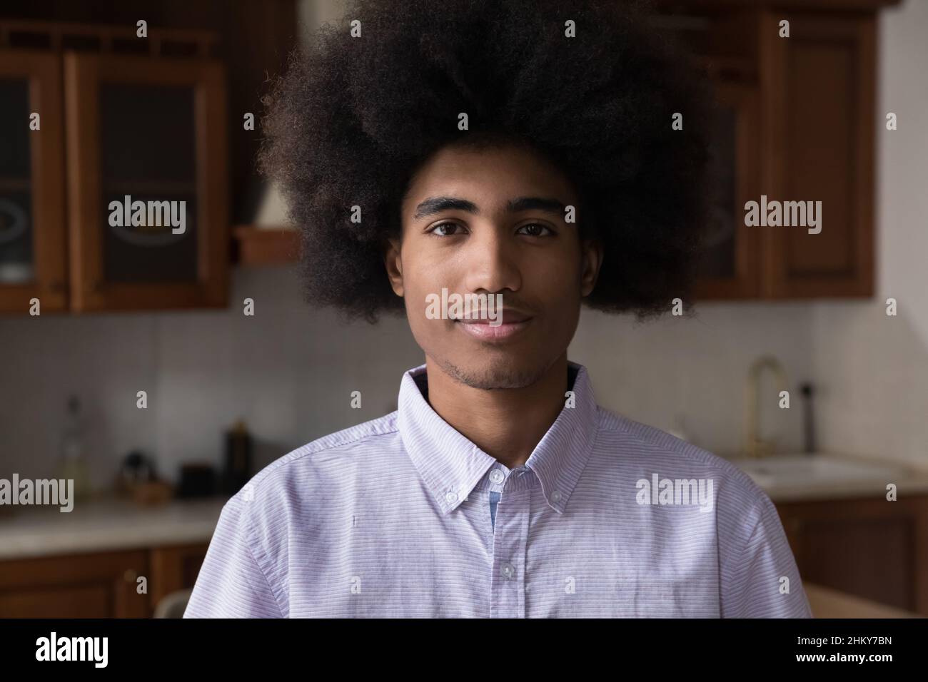 Positive African teenage guy with Afro hairdo home head shot Stock Photo
