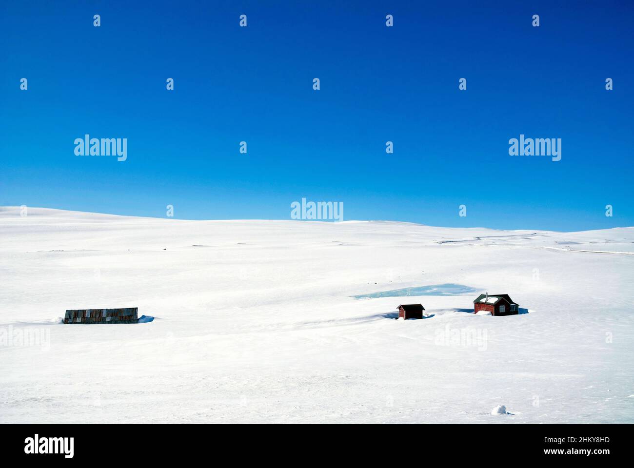 Houses in the snow covered plains of the Hardangervidda Stock Photo