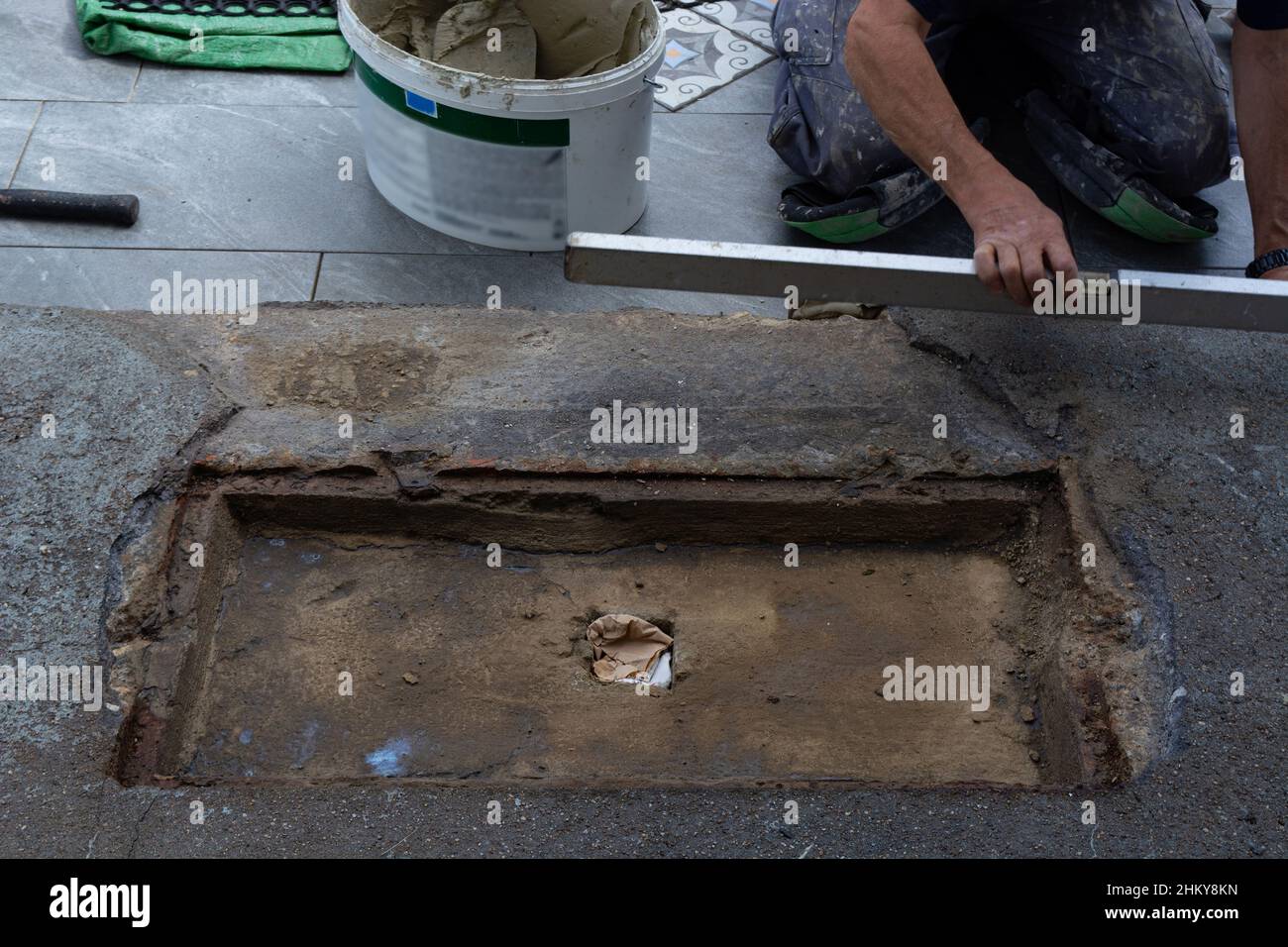 Laying ceramic floor tiles - man hands closeup Stock Photo