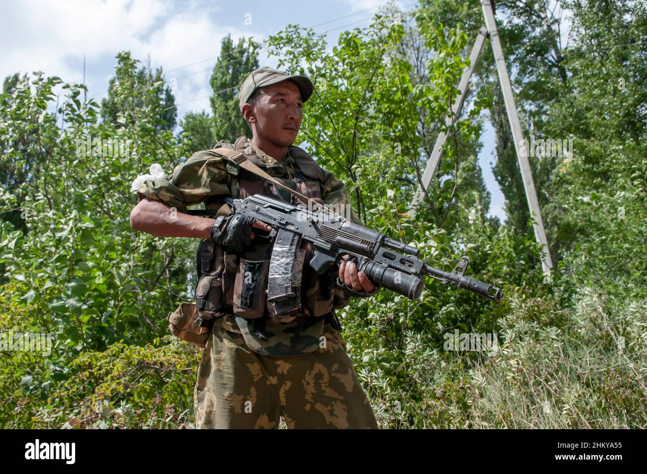 An ethnic Russian soldier armed with AK-74M Kalashnikov with GP-34 grenade launcher stands guard at a checkpoint during the Russo-Georgian War August 2008 Stock Photo