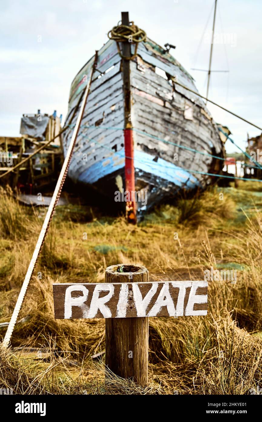 Hand painted 'private' sign in front of old wooden boat Stock Photo