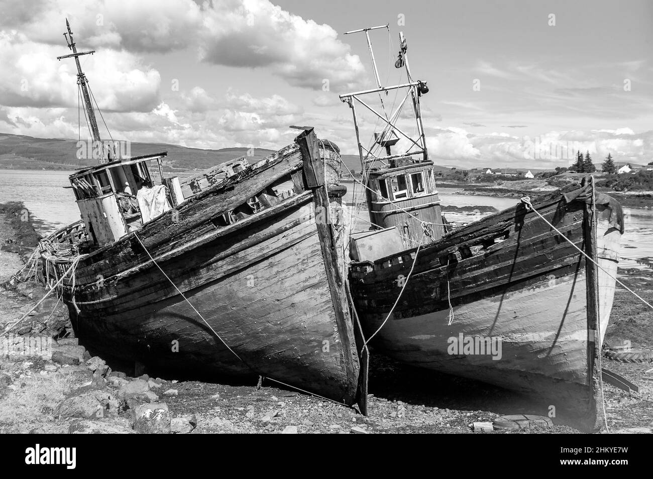 Black and white photo of two abandoned wooden herring fishing boats on the seashore of  the Isle of Mull, Argyll, Inner Hebrides, Scotland, UK, Europe Stock Photo