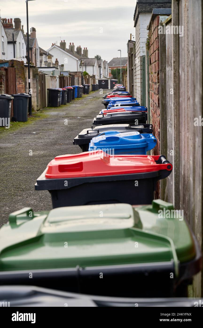 Many coloured wheelie bins lined up in alley way,Lancahire,UK Stock Photo