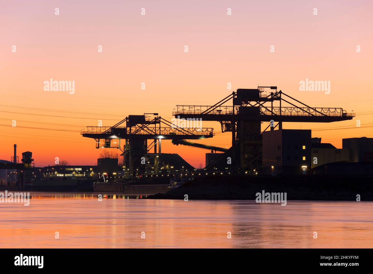 Cranes in a harbour at sunrise or sunset Stock Photo