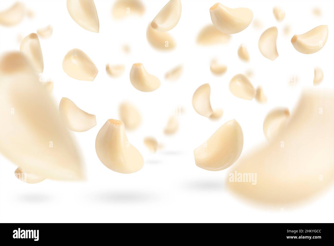 Set of peeled garlic cloves falling on a white background with ...