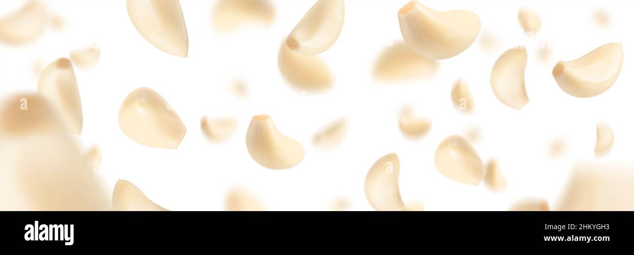 Set of peeled garlic cloves falling on a white background with ...