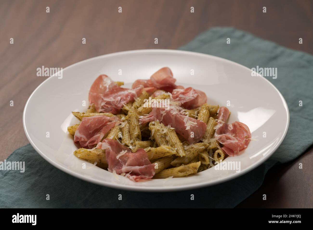 Penne pasta with capocollo, pesto and parmesan cheese, shallow focus