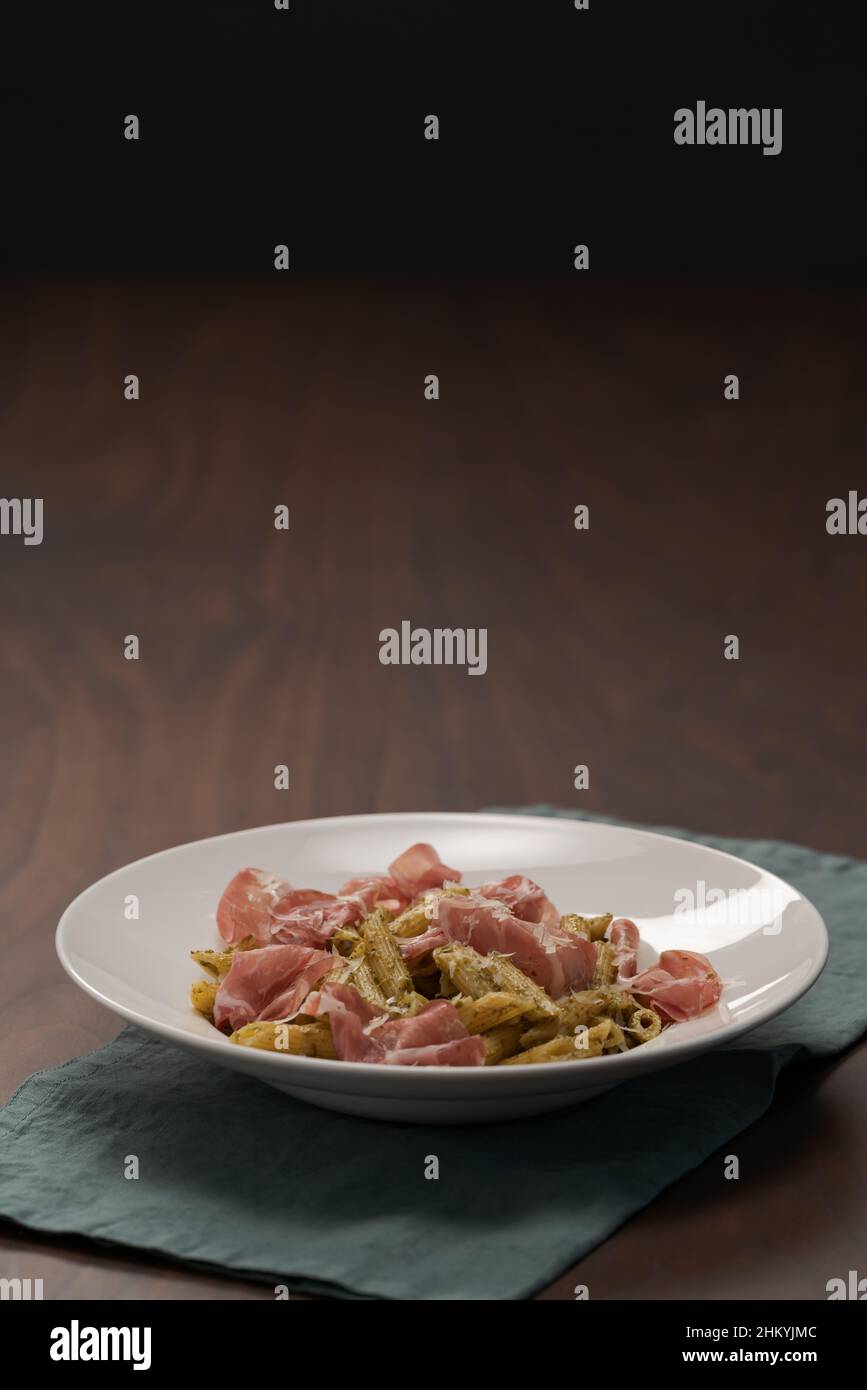 Penne pasta with capocollo, pesto and parmesan cheese, shallow focus