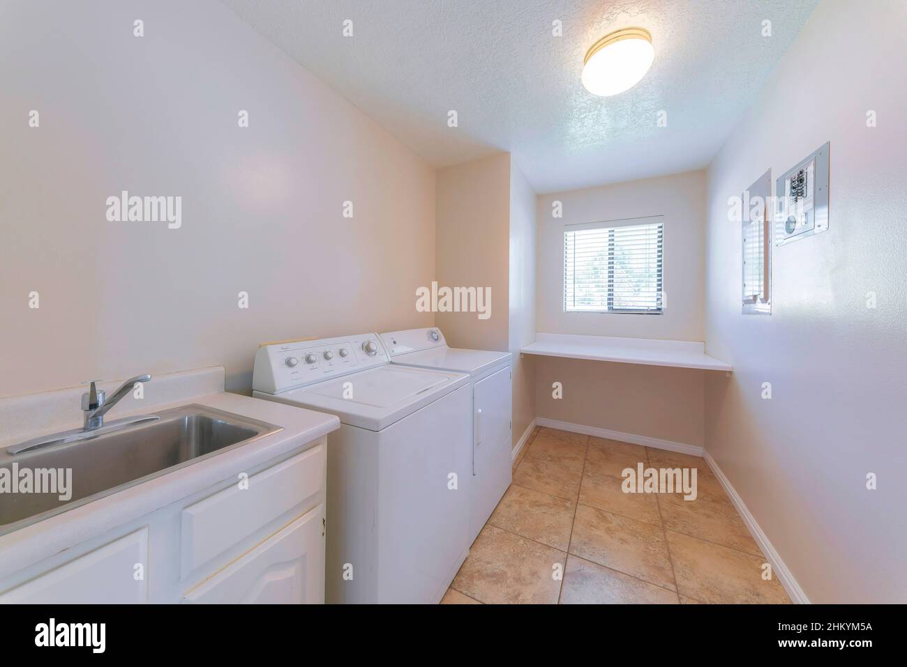 Laundry room interior with vanity and stainless steel sink Stock Photo ...