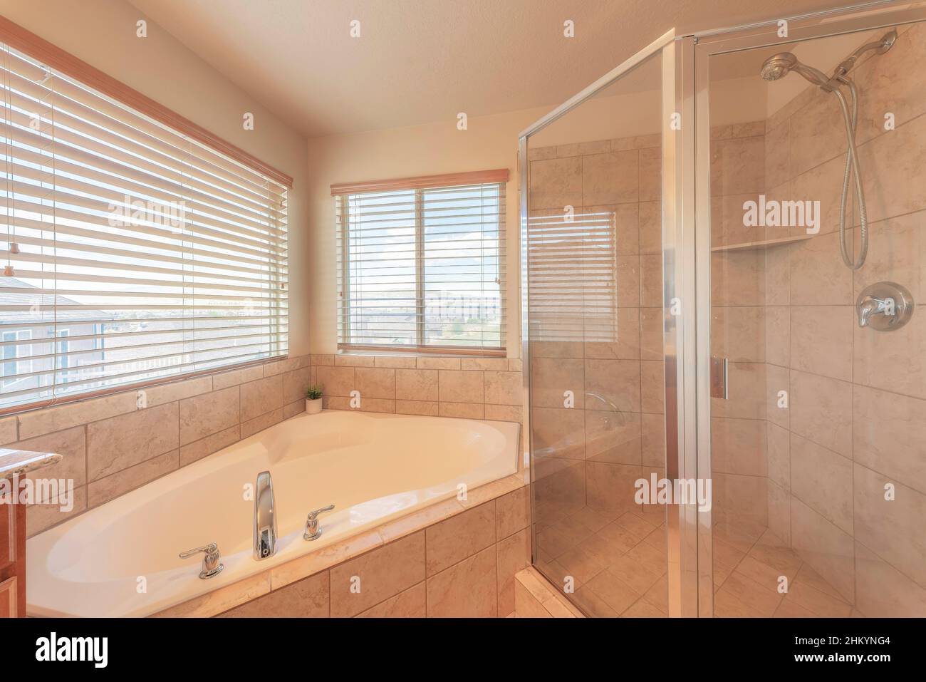 Corner bathtub and shower stall with ceramic tiles surround Stock Photo