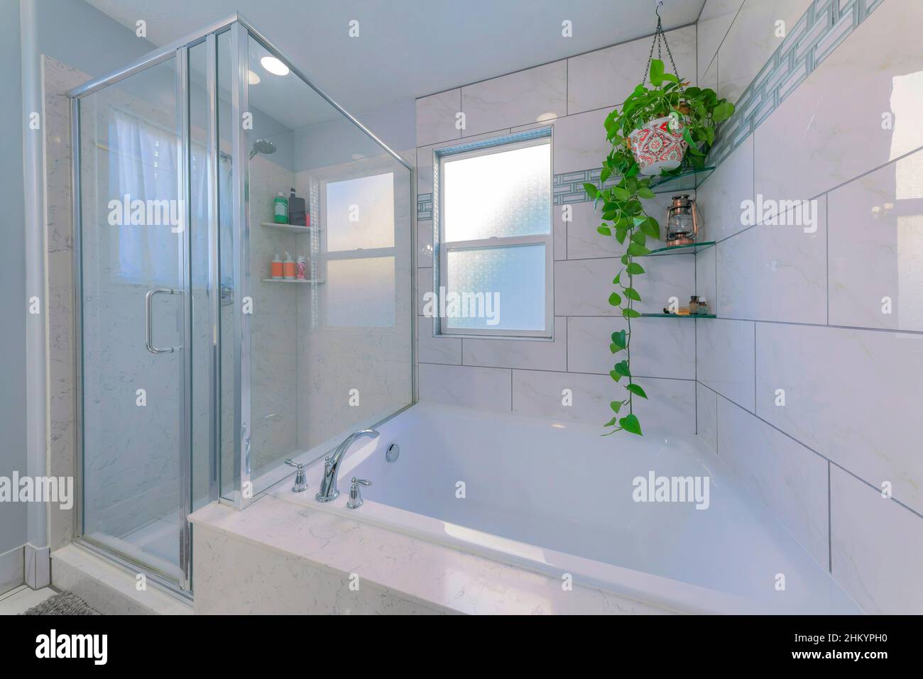 Bathroom interior with marble tiles surround and glass corner shelves