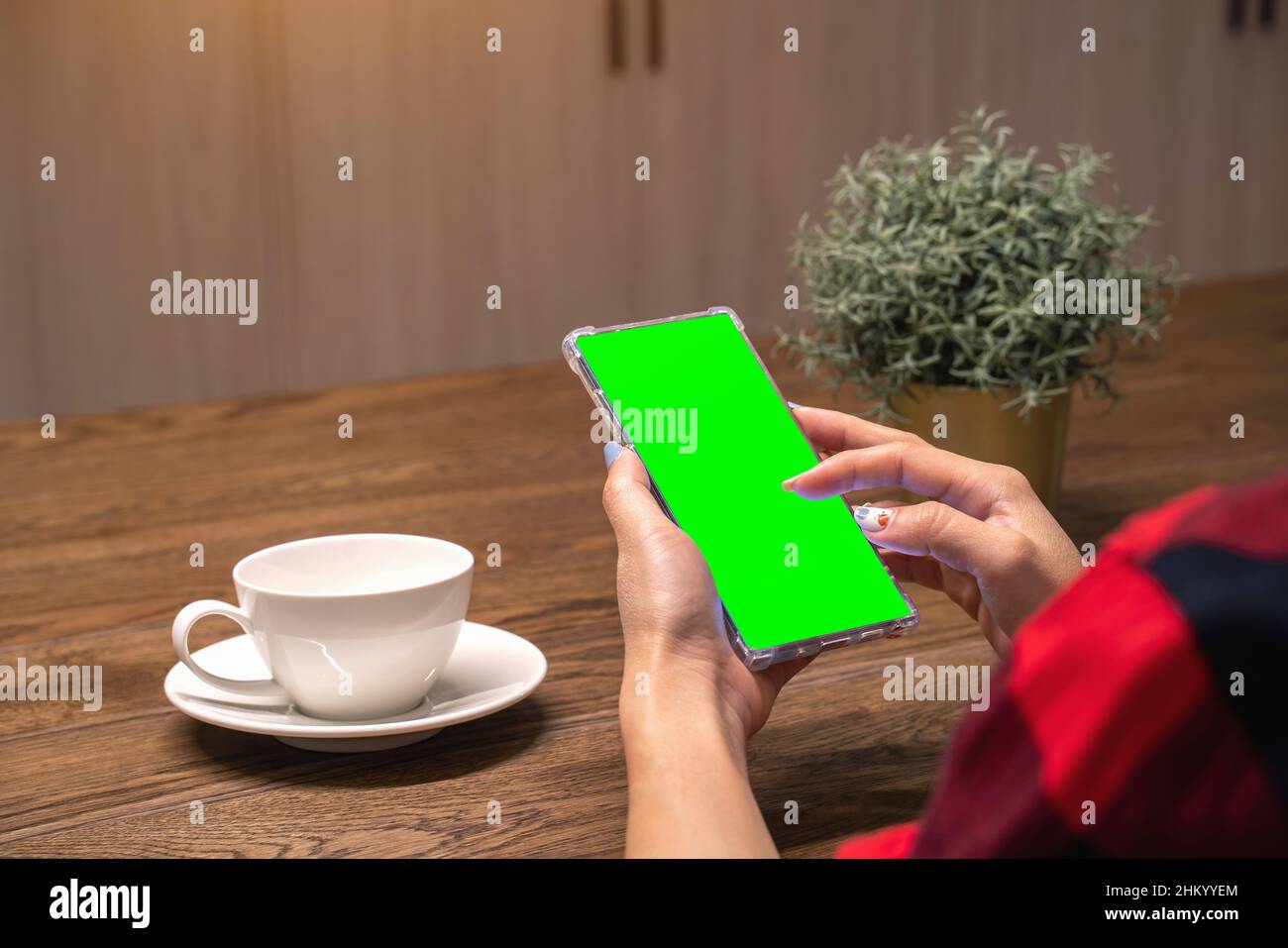 Woman using her smartphone with green screen. Stock Photo