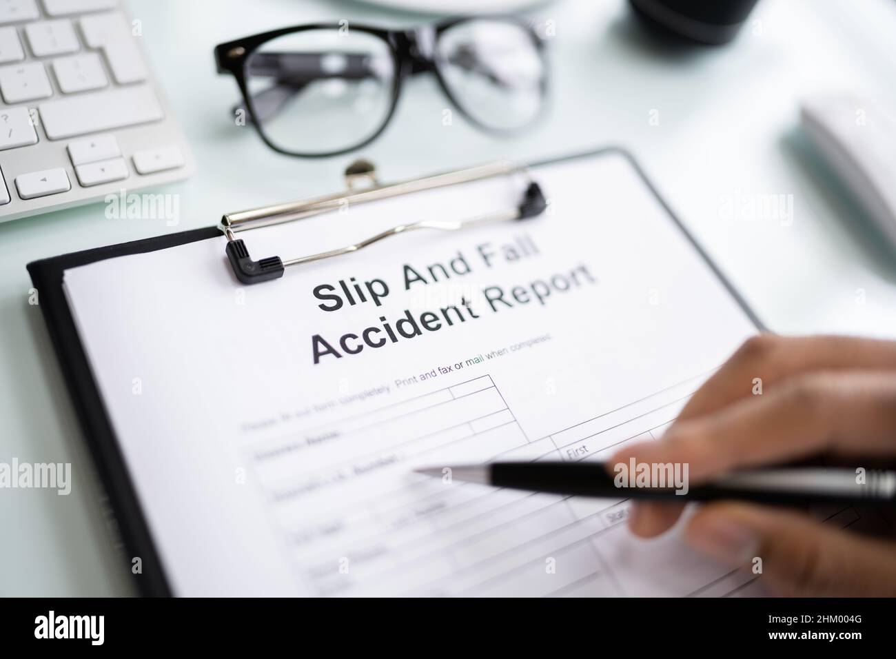 Closeup Of A Man's Hand Filling Slip And Fall Accident Report Stock