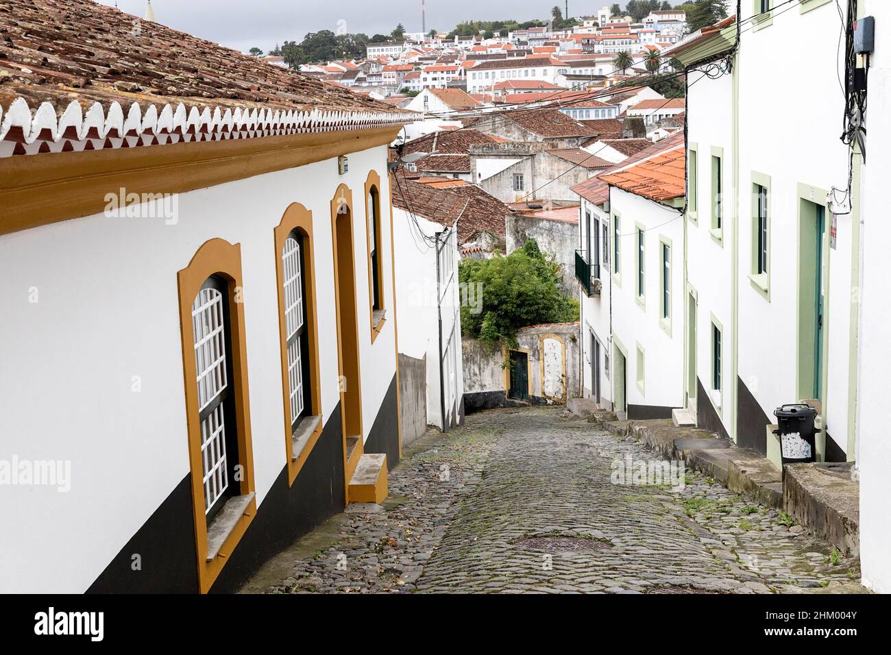 Narrow cobblestone street with colorful houses in a row, Angra do Heroismo, Portugal, Azores, Terceira Island Stock Photo