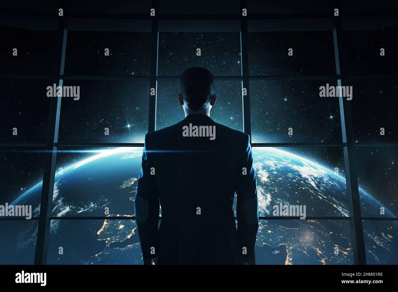 Abstract image of young, successful businessman looking at the earth at night Stock Photo