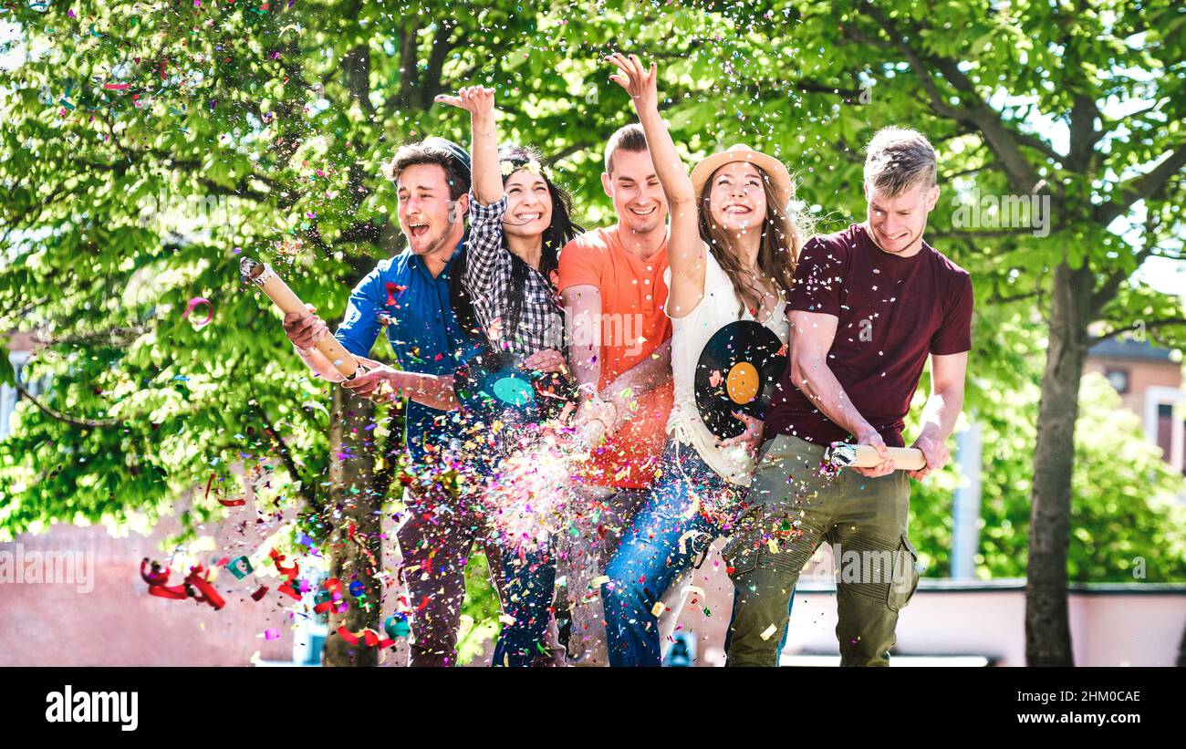 Happy amused friends having fun out side cheering with confetti - Young ...