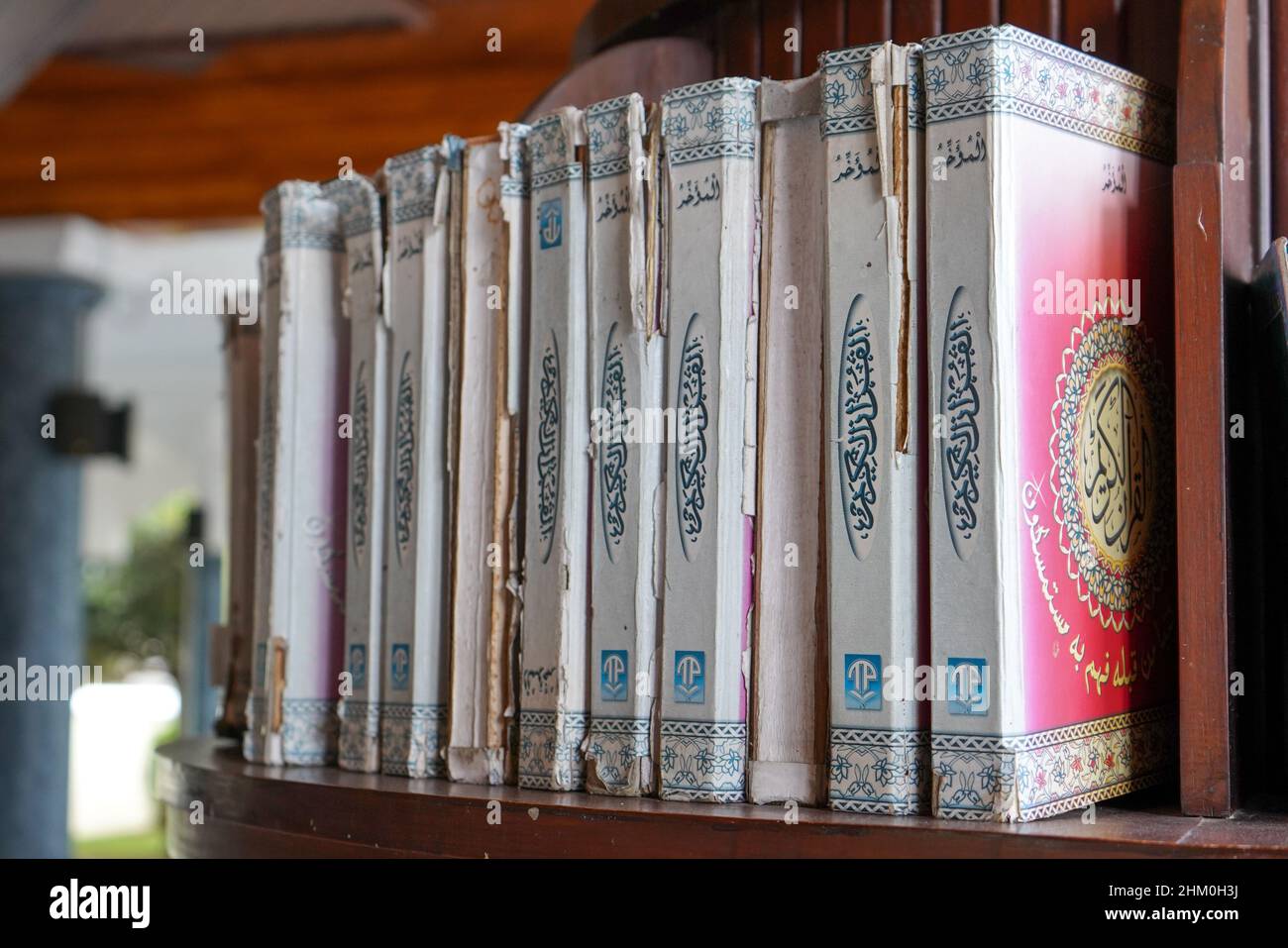 Collection of the Koran and hadith in the library of the mosque that is lined on the wall stands upright, vertical and vertically. Stock Photo