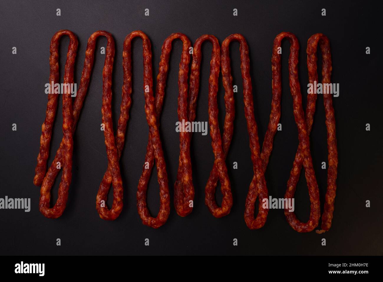 Cabanossi, dry sausage isolated on a black background Stock Photo - Alamy