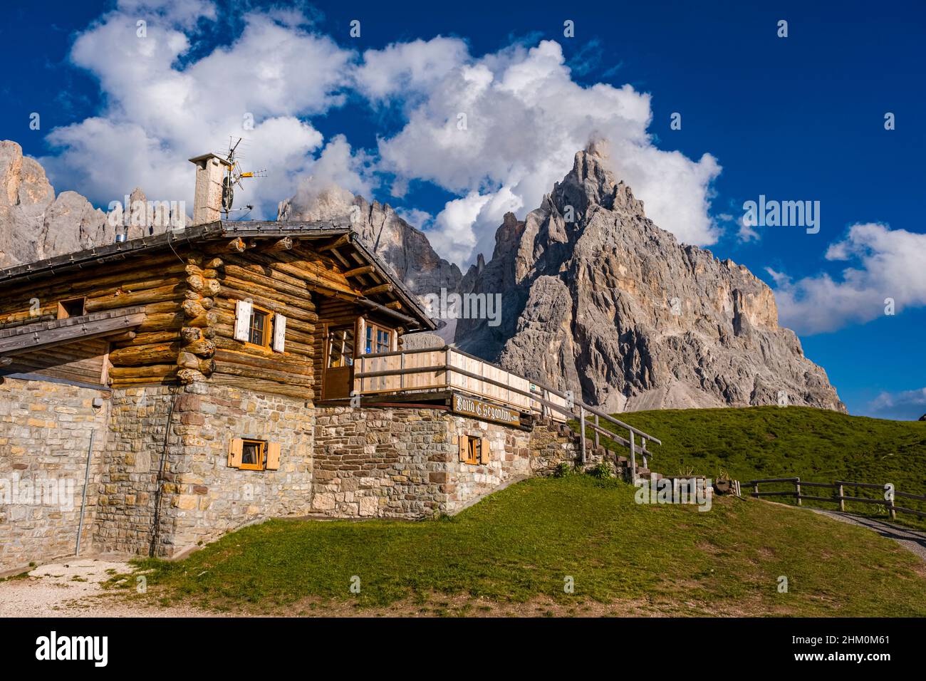 Baita Segantini, an alpine hut, with summits and rock faces of the Pala group, Cimon della Pala, one of the main summits, standing out, in the distanc Stock Photo