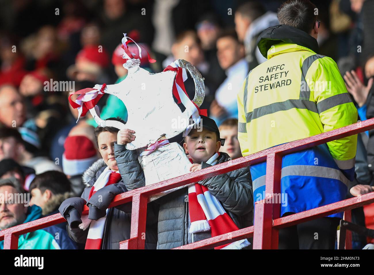 A young fan holds afoot a sliver foil F A Cup ahead of todays game Stock Photo