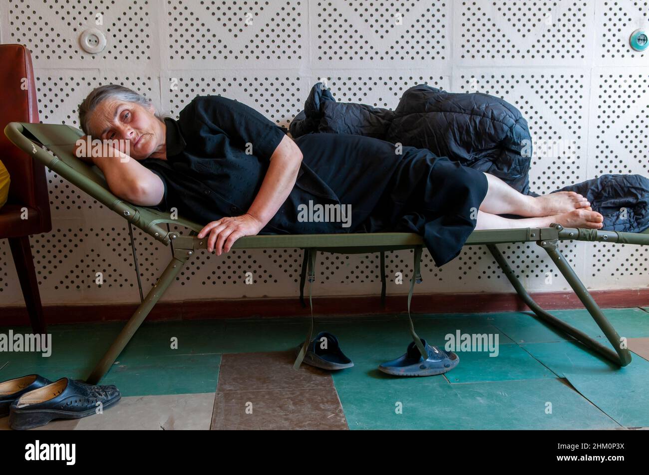 Displaced Georgian woman lies on a stretcher at a temporary shelter for internal displaced people, many of them from the breakaway province of South Ossetia in the city of Tbilisi during the Russo-Georgian War August 2008 Stock Photo