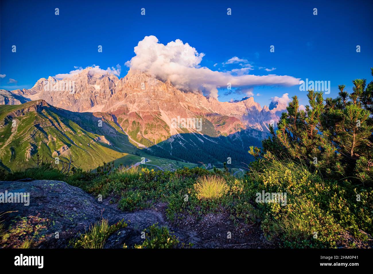 Summits and rock faces of the Pala group, Cimon della Pala, one of the main summits, covered in clouds, at sunset. Stock Photo