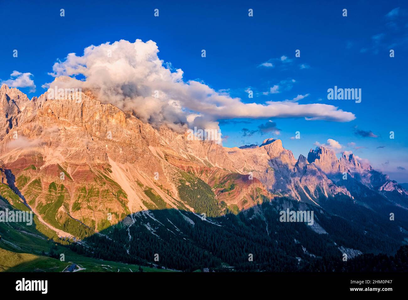 Summits and rock faces of the Pala group, Cimon della Pala, one of the main summits, covered in clouds, at sunset. Stock Photo