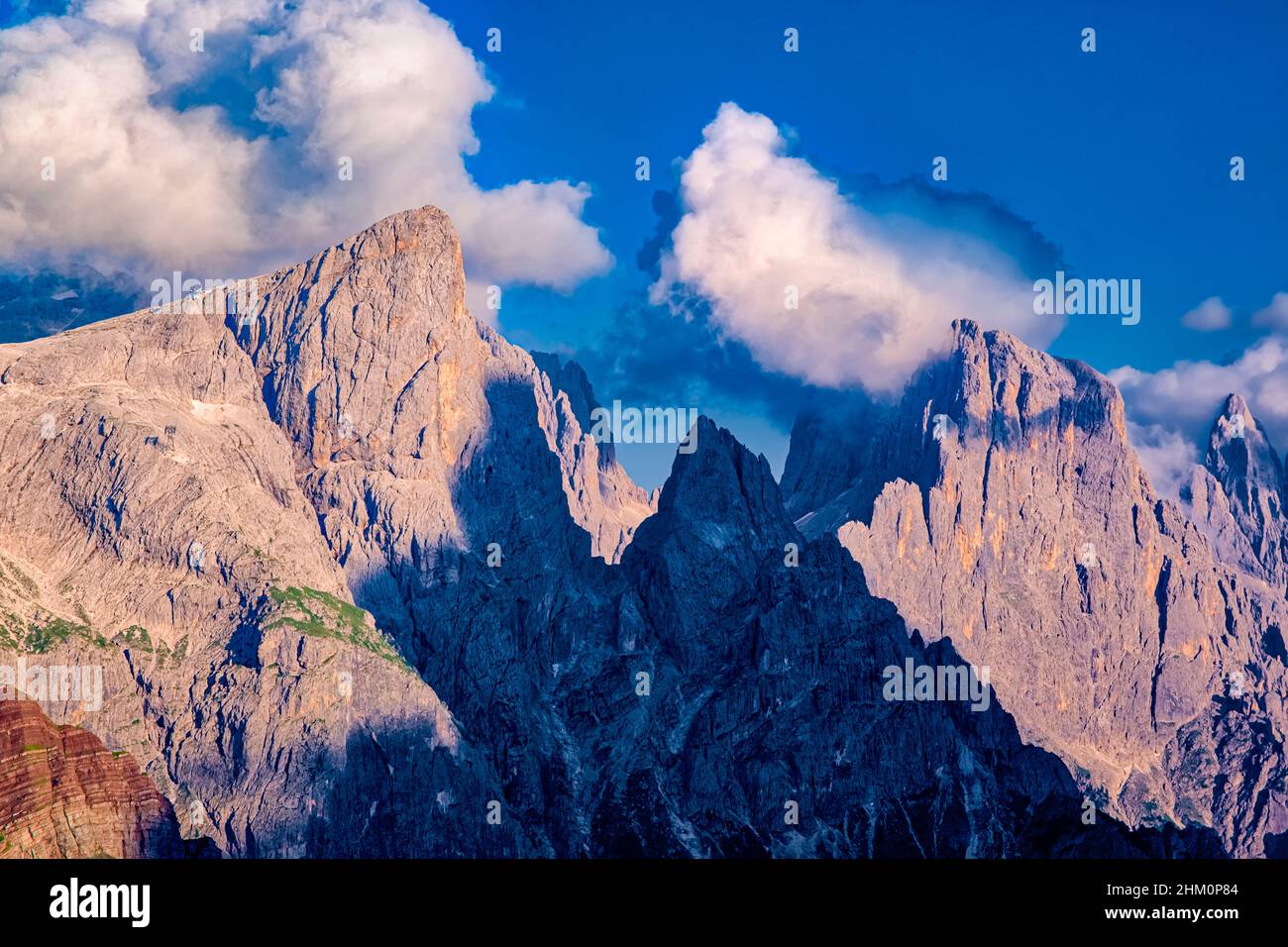 Cima della Rosetta and Cima di Val di Roda, two of the main summits of the southern Pala group, partly covered in clouds, at sunset. Stock Photo