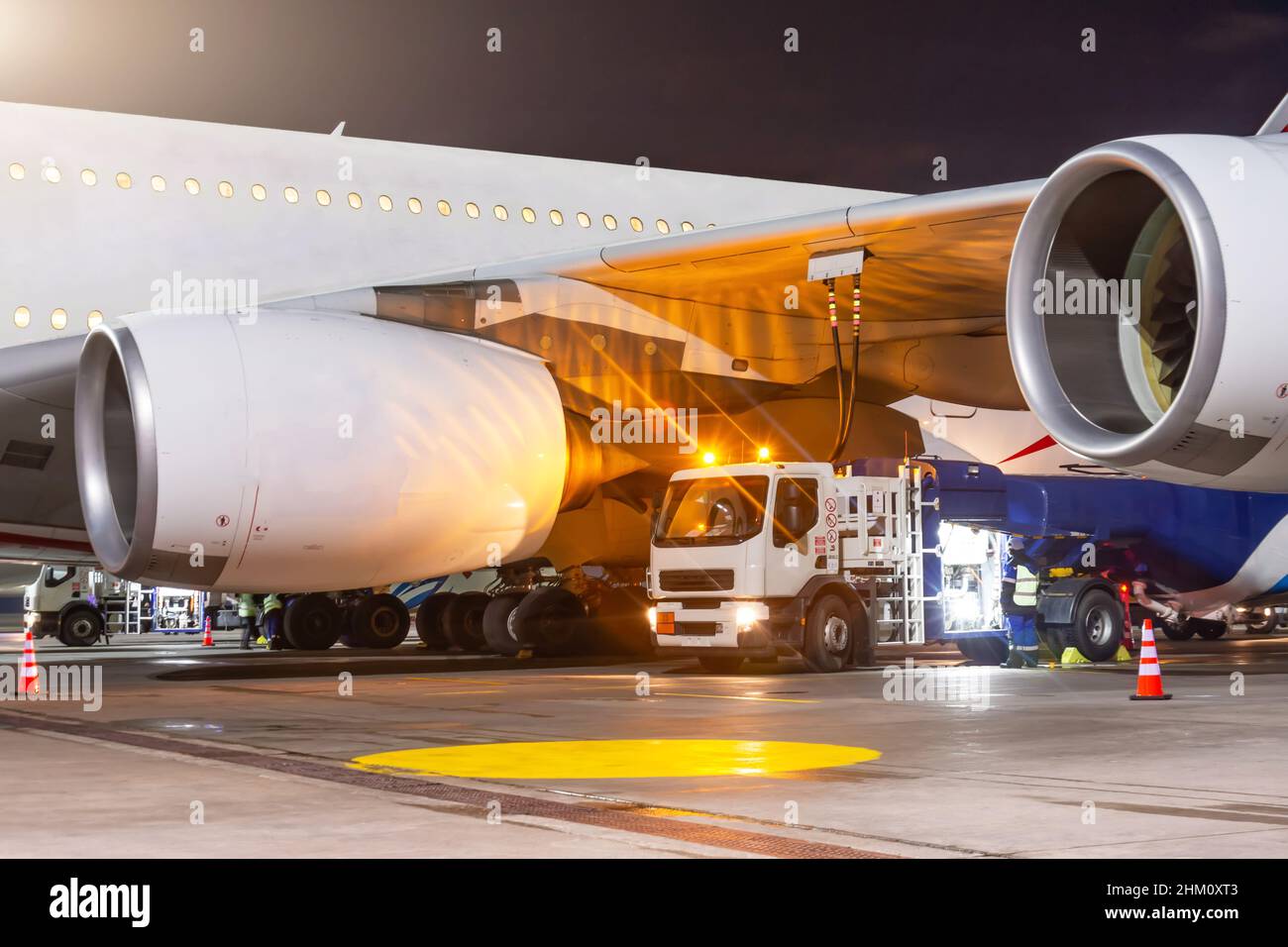 Process of aircraft jet airplane refueling by high pressure fuel supply truck at night Stock Photo