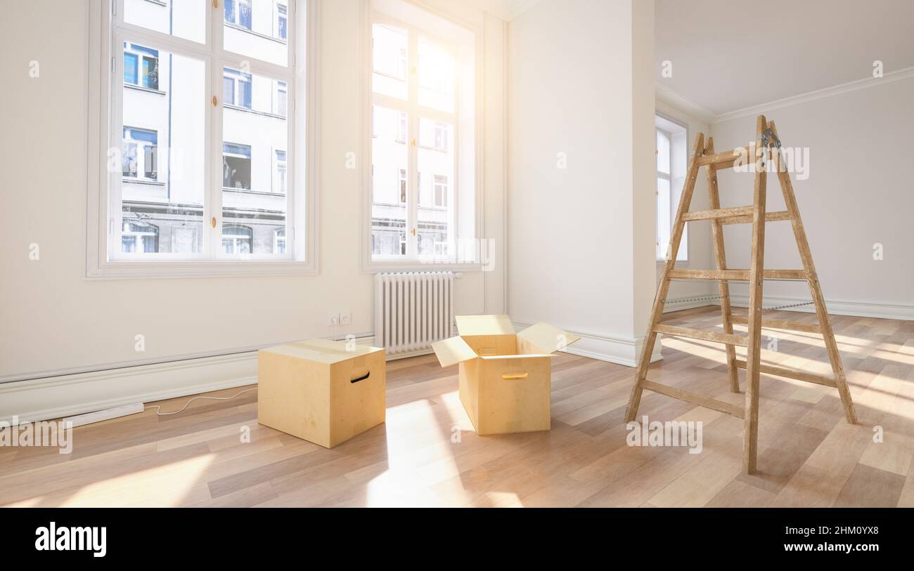 Moving boxes in empty room with ladder as relocation or forwarding agency concept image Stock Photo
