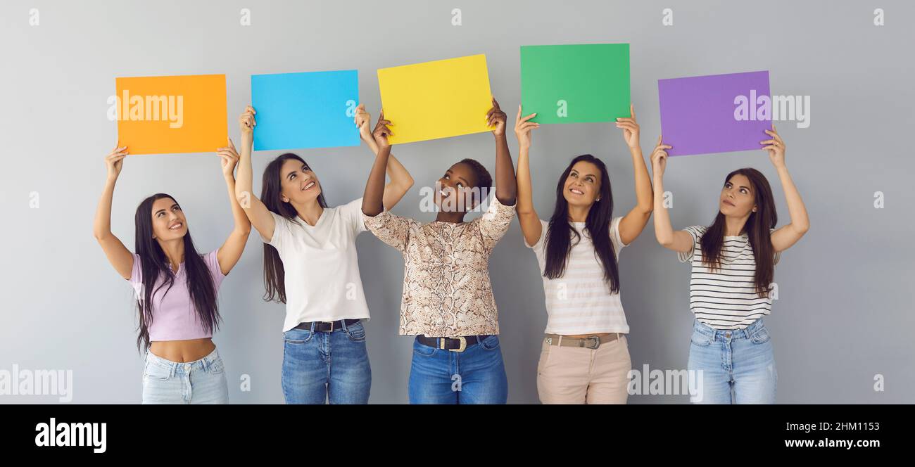Banner background with group of happy young women showing mockup sheets of  paper Stock Photo - Alamy