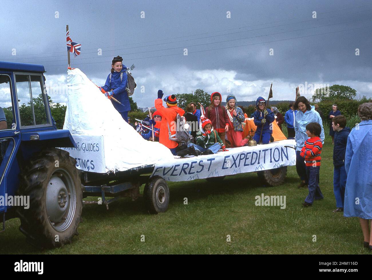 1977, historical, on the back of a tractor, brownies and girl guides in outdoor gear on a decorated parade float commerating the Everest Expedition of the same year, taking part in a village carnival to celebrate the silver jubilee of Her Majesty, Queen Elizabeth II, England, UK. Stock Photo