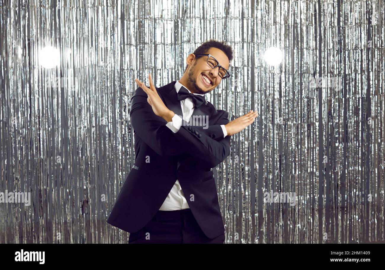 Funny young African American man in suit and glasses dancing and having ...
