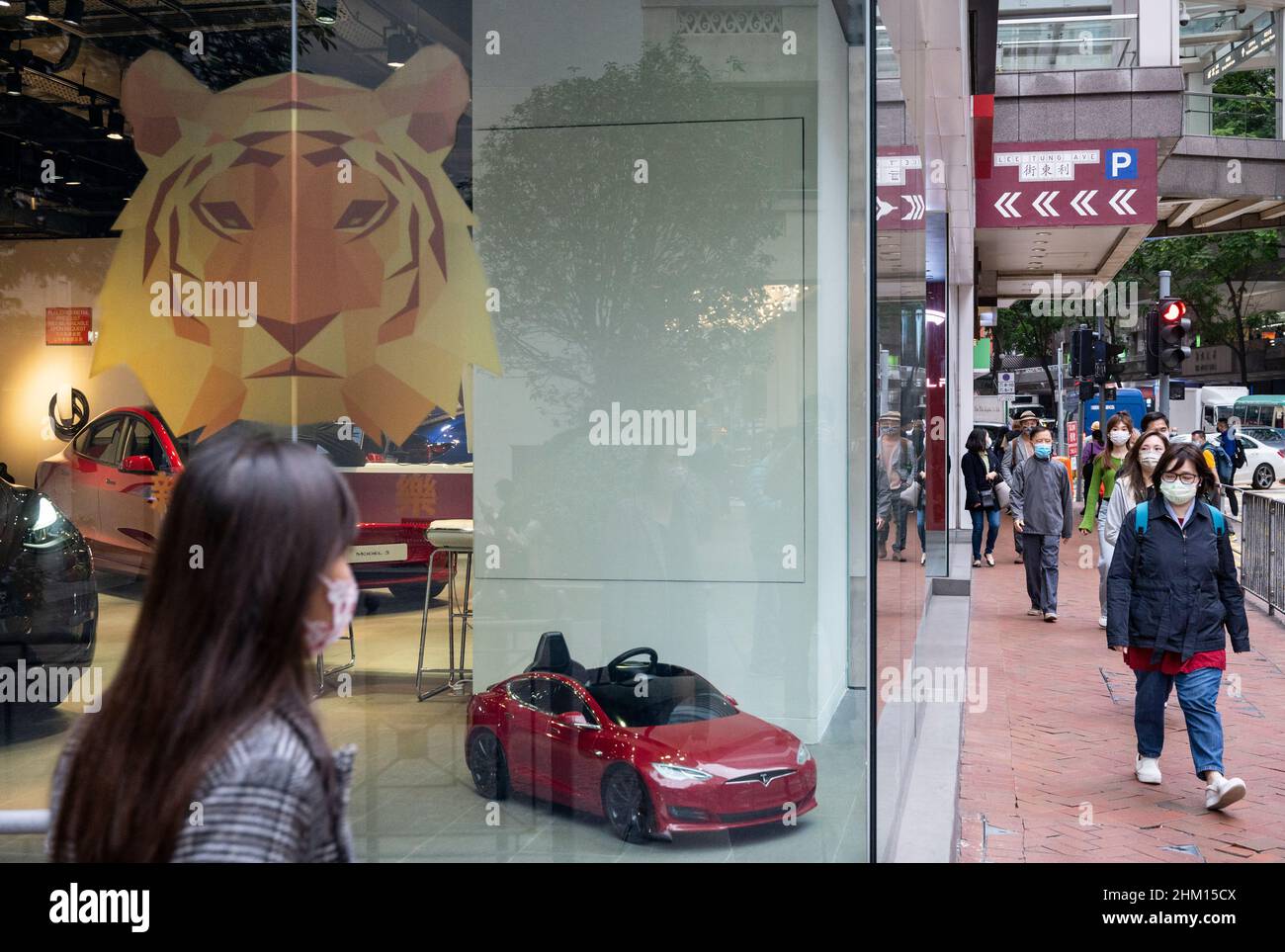 Hong Kong, China. 06th Feb, 2022. Pedestrians walk past the American electric company car Tesla Motors official authorized car dealer store as it displays a Chinese new year, of the Tiger theme sticker in Hong Kong. (Photo by Budrul Chukrut/SOPA Images/Sipa USA) Credit: Sipa USA/Alamy Live News Stock Photo