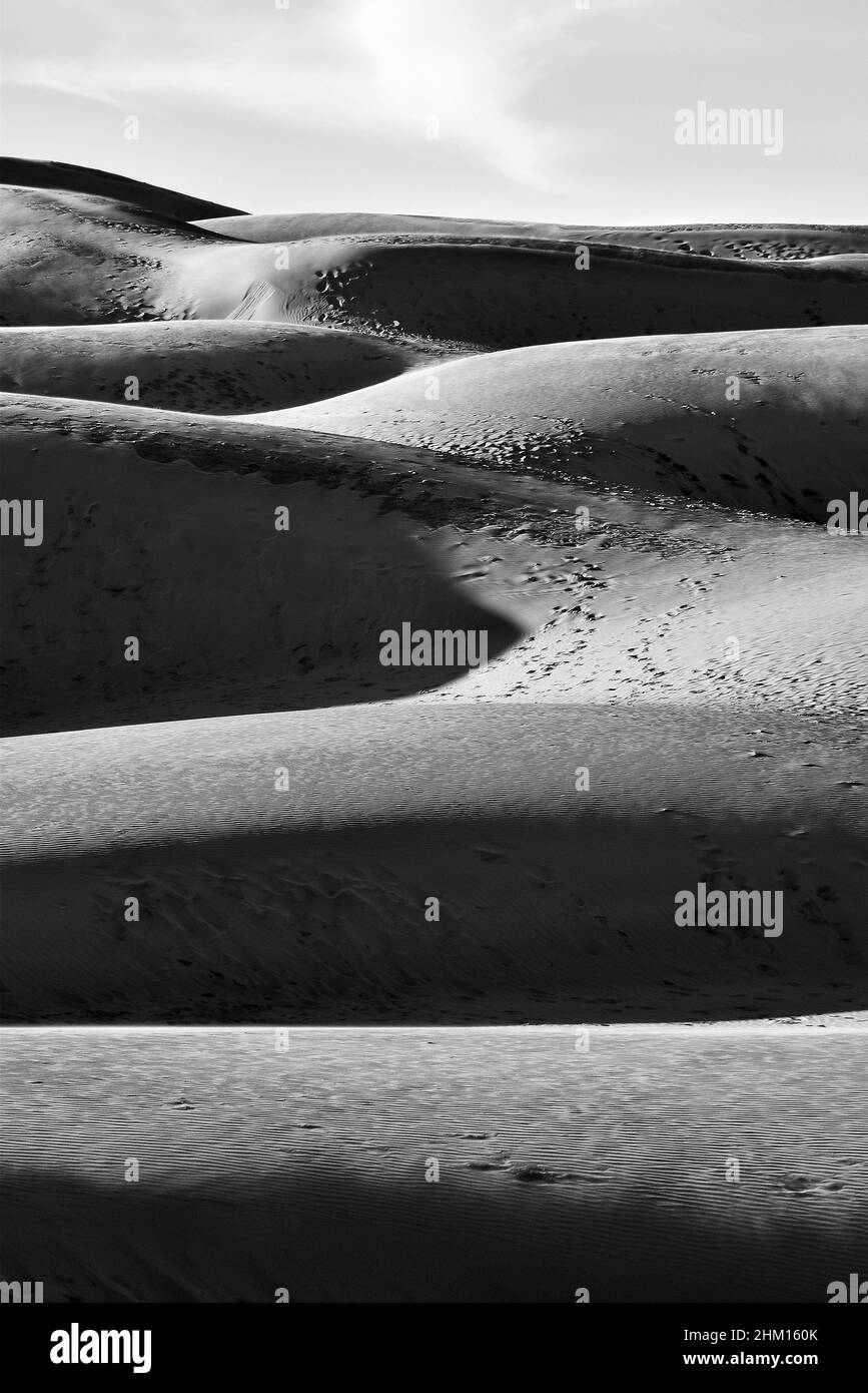 Black and White Sand Dune with Footprints, Sky and Cloud in the Morning Stock Photo