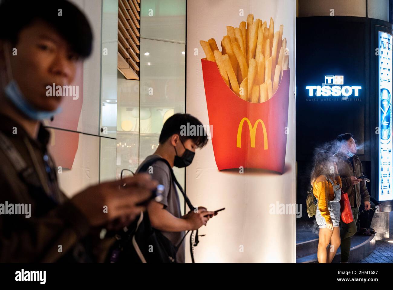 People stand outdoors near a McDonald s commercial advertisement