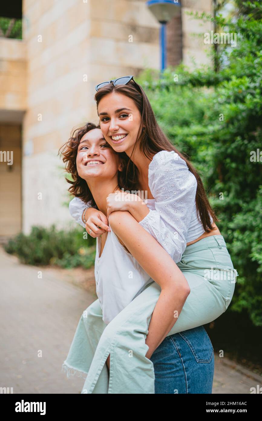 Black girl giving friend a piggyback ride Stock Photo - Alamy