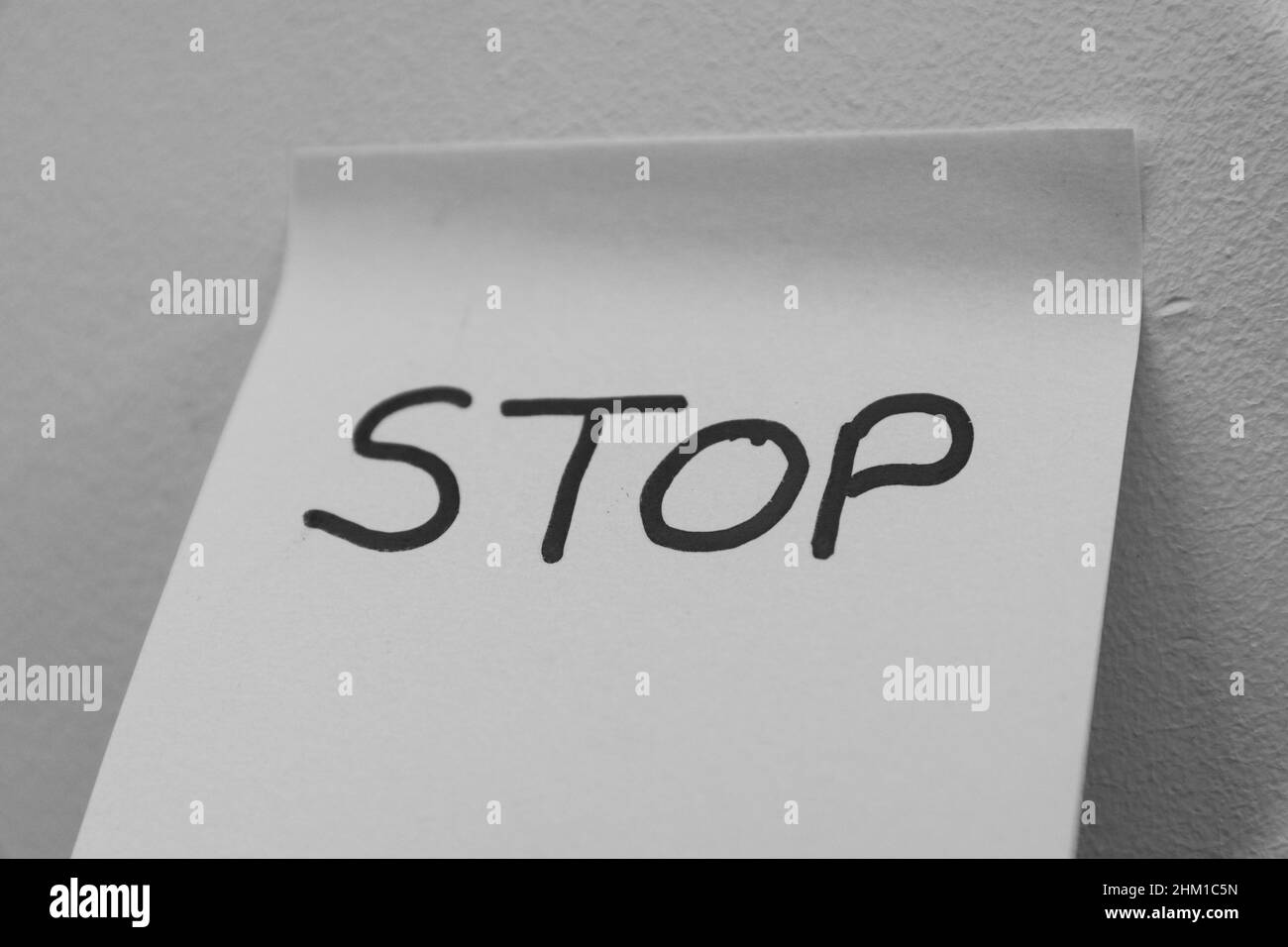 Stop hand wrote on a sticky note, isolated. Danger, safeguard, half, protection concept background. Copy space, Simple concepts. . Stock Photo