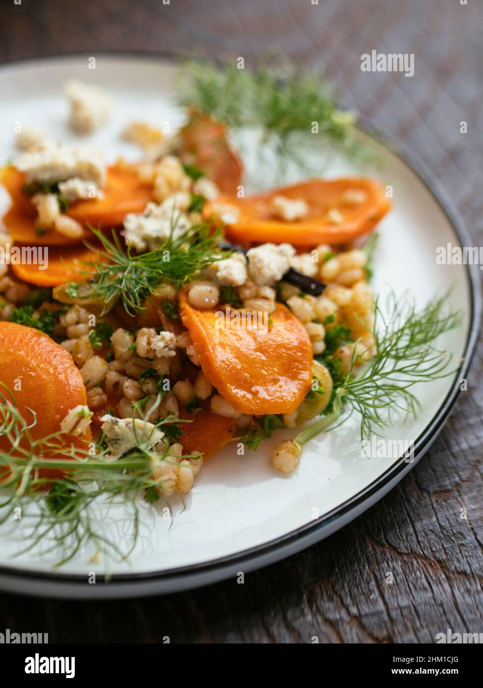 Home made roasted carrot and barley salad with vegan feta. Stock Photo