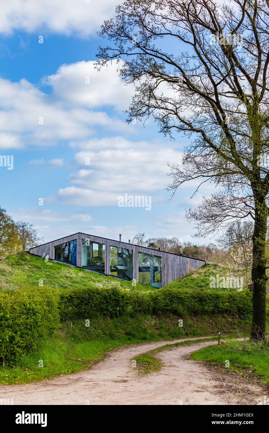 Diepenheim, The Netherlands - April 25, 2021: Modern sustainable house embedded in small hill the landscape in Hof van Twente in The Netherlands Stock Photo