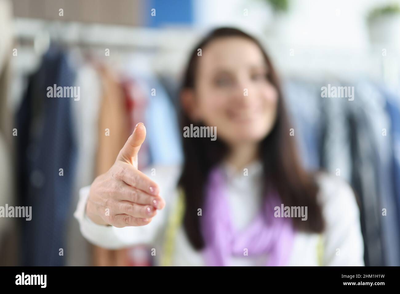 Woman seamstress holds out hand for handshake closeup Stock Photo