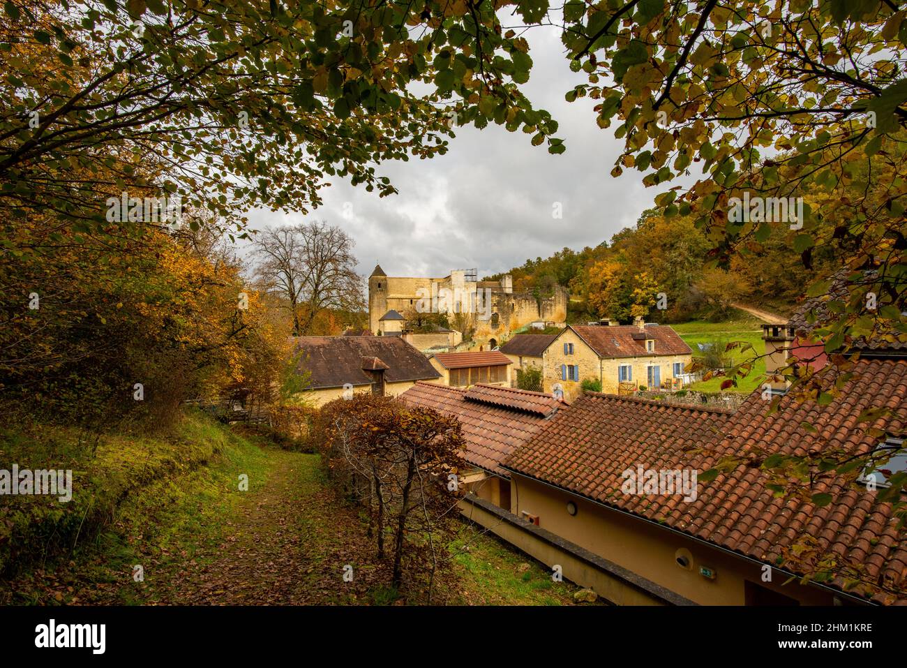 A framed view on the fortified church of Coly-Saint-Armand in Perigord, France, taken on an overcast autumn afternoon with no people. Stock Photo