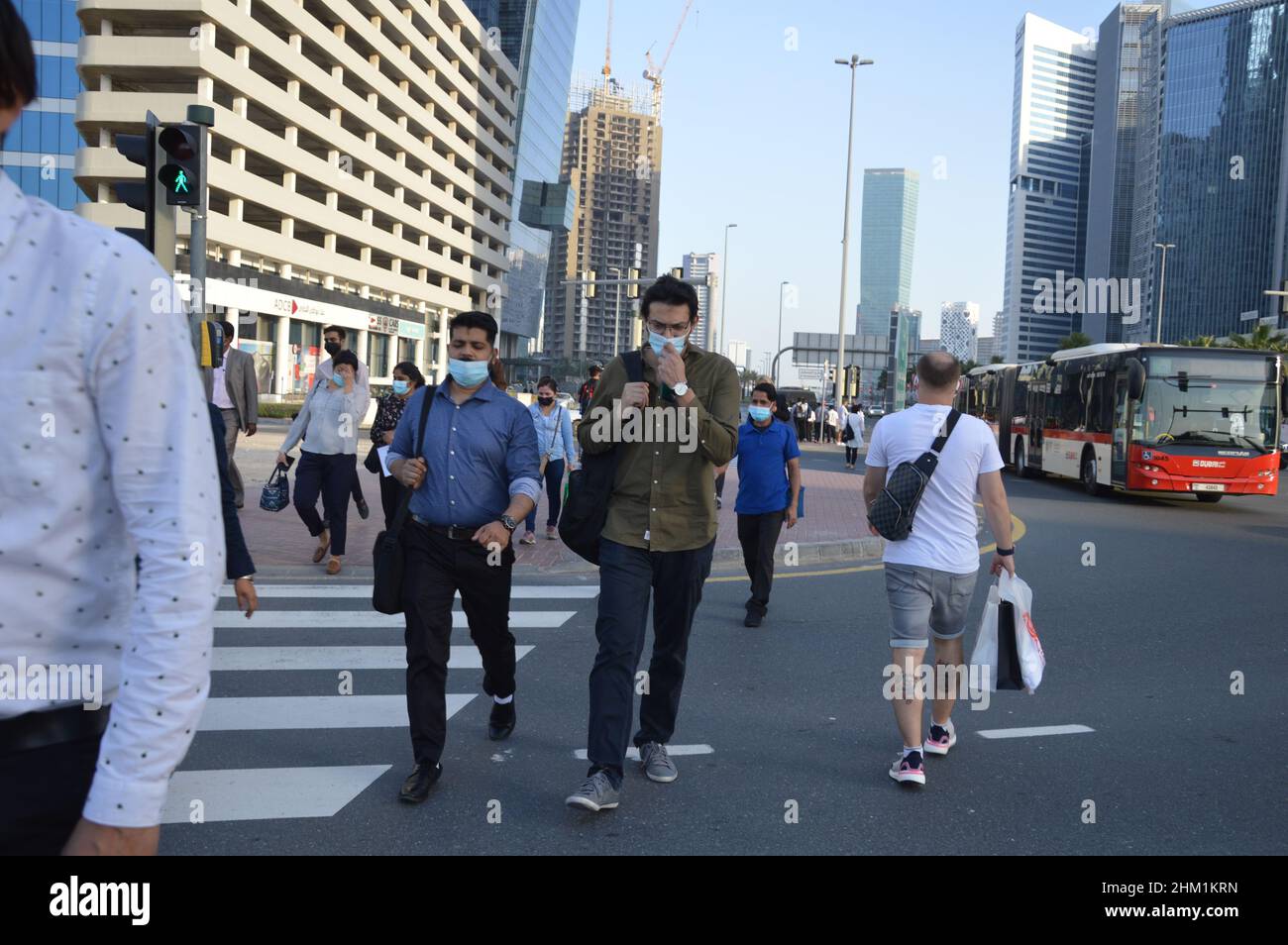 Pedestrians walk wearing face masks to protect and to prevent the