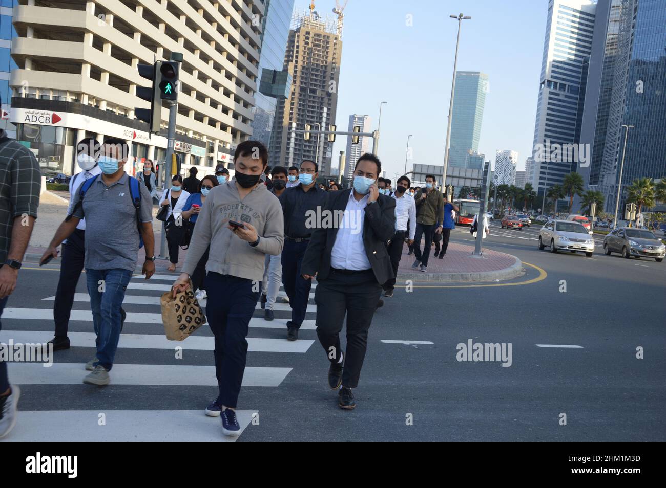 Pedestrians walk wearing face masks to protect and to prevent the