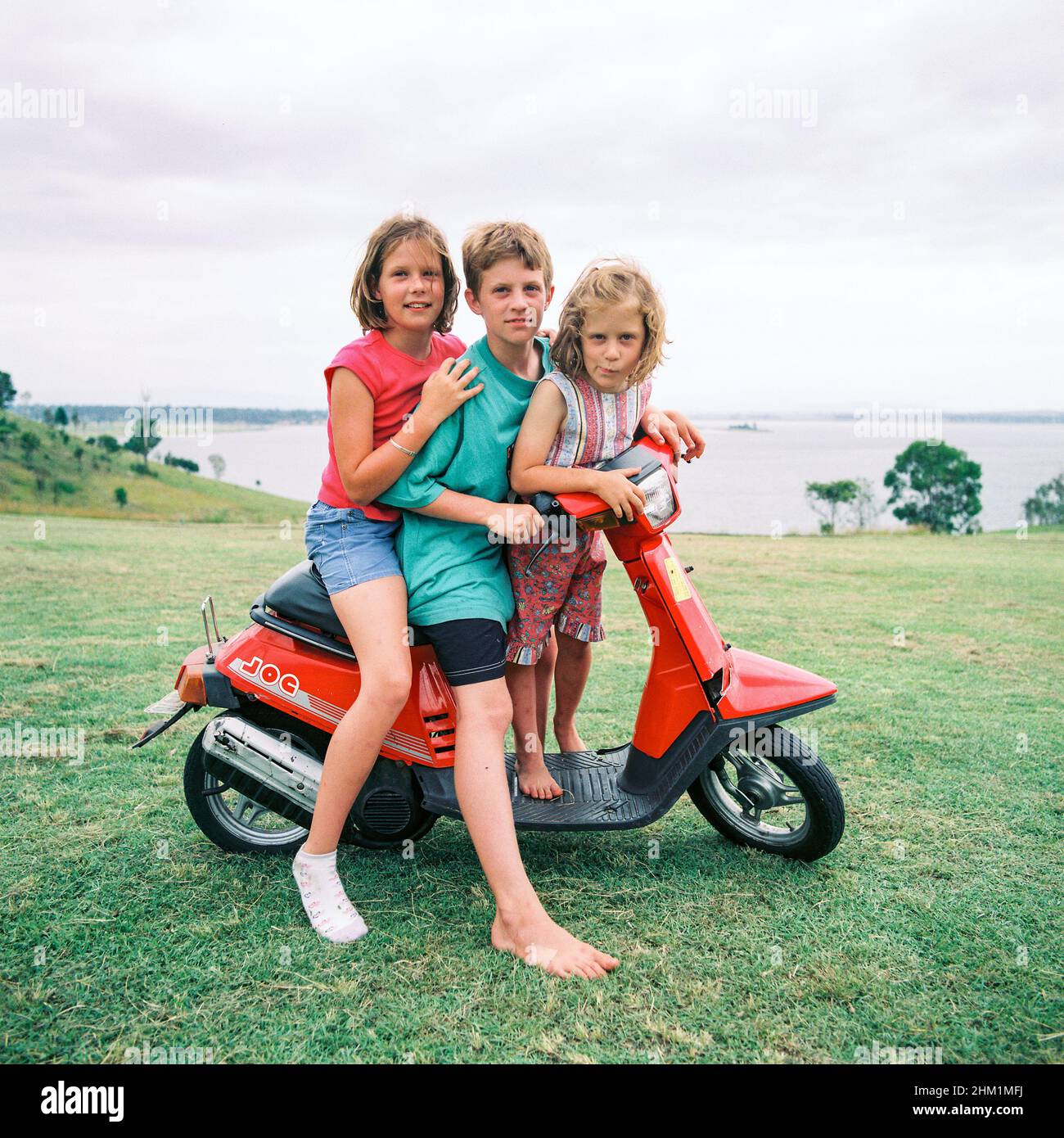 Kids playing on a Honda moped around Somerset Dam, Queensland Australia. Stock Photo